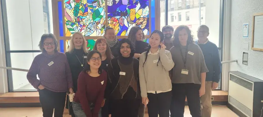 a group of people standing in front of a stained glass window
