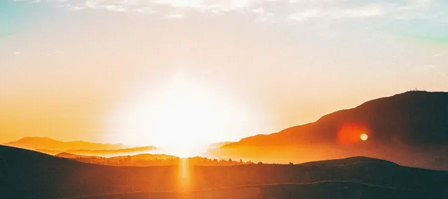 a sunset over some hills