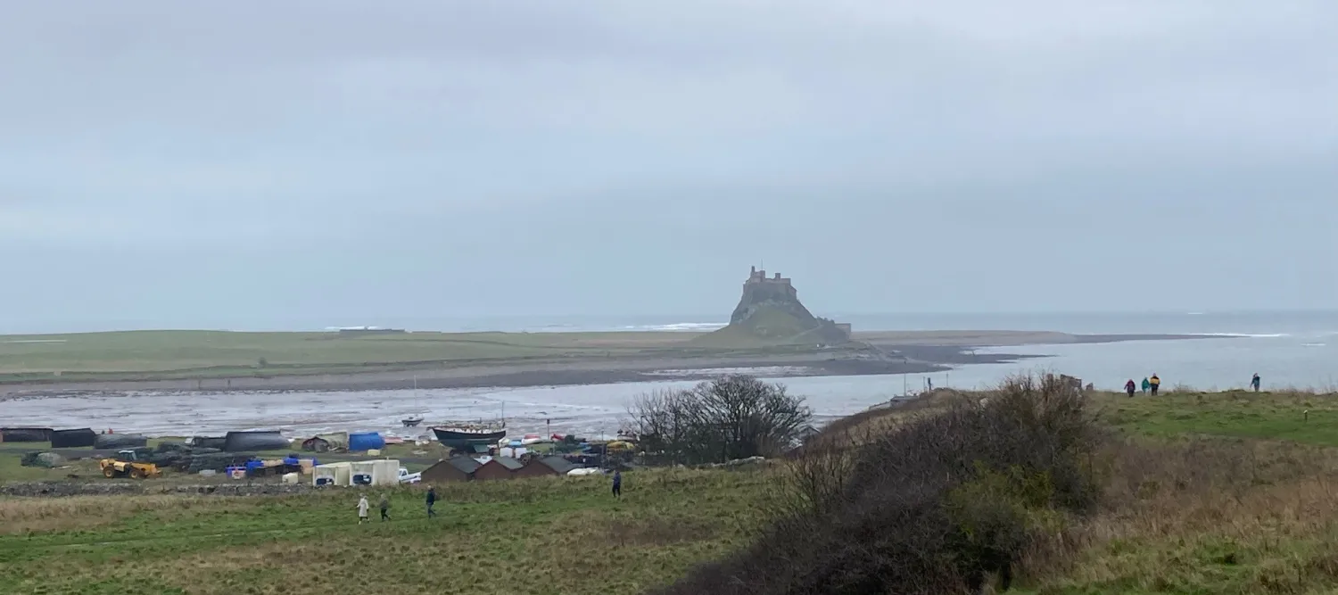The view of a castle in the distance as seen from shore