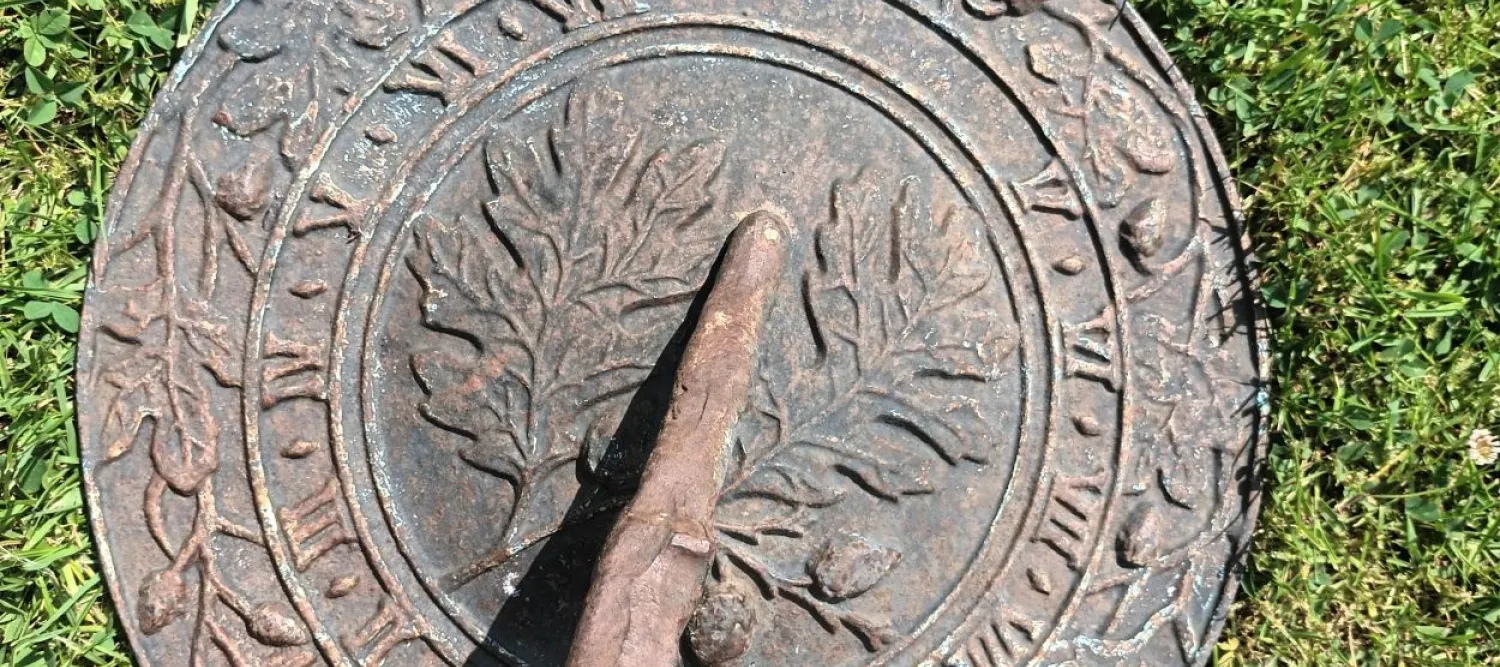 A sun dial on a grass floow