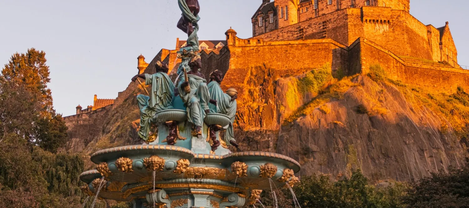 a fountain with edinburgh castle in the background