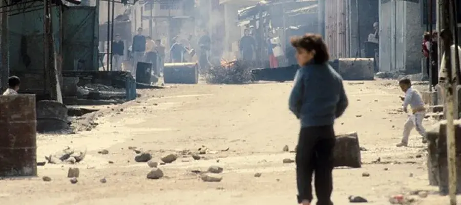 A person walking down a sand road in the middle east