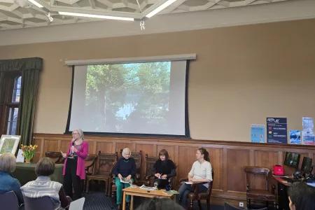 people standing in front of a projector in a large room giving a talk