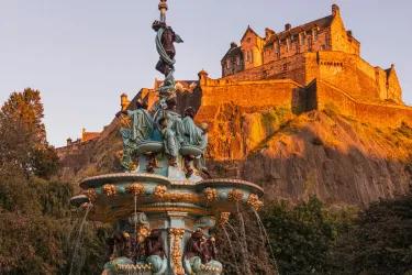 a fountain with edinburgh castle in the background