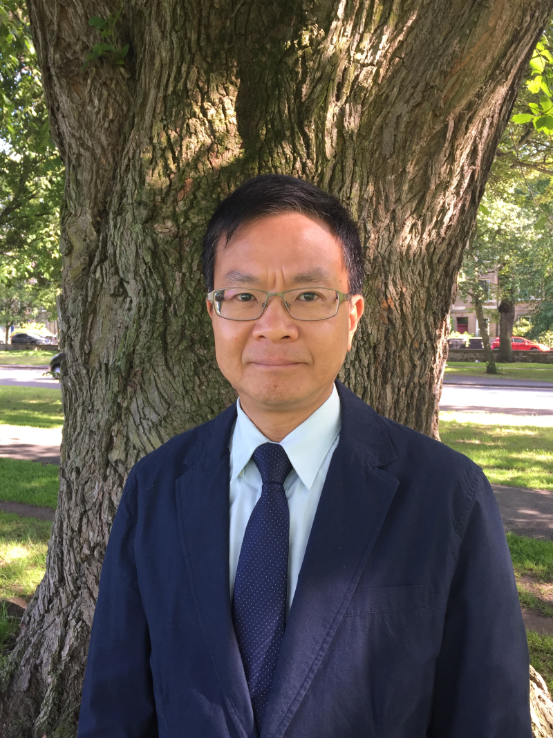 Eric Leung standing outside Infront of a tree