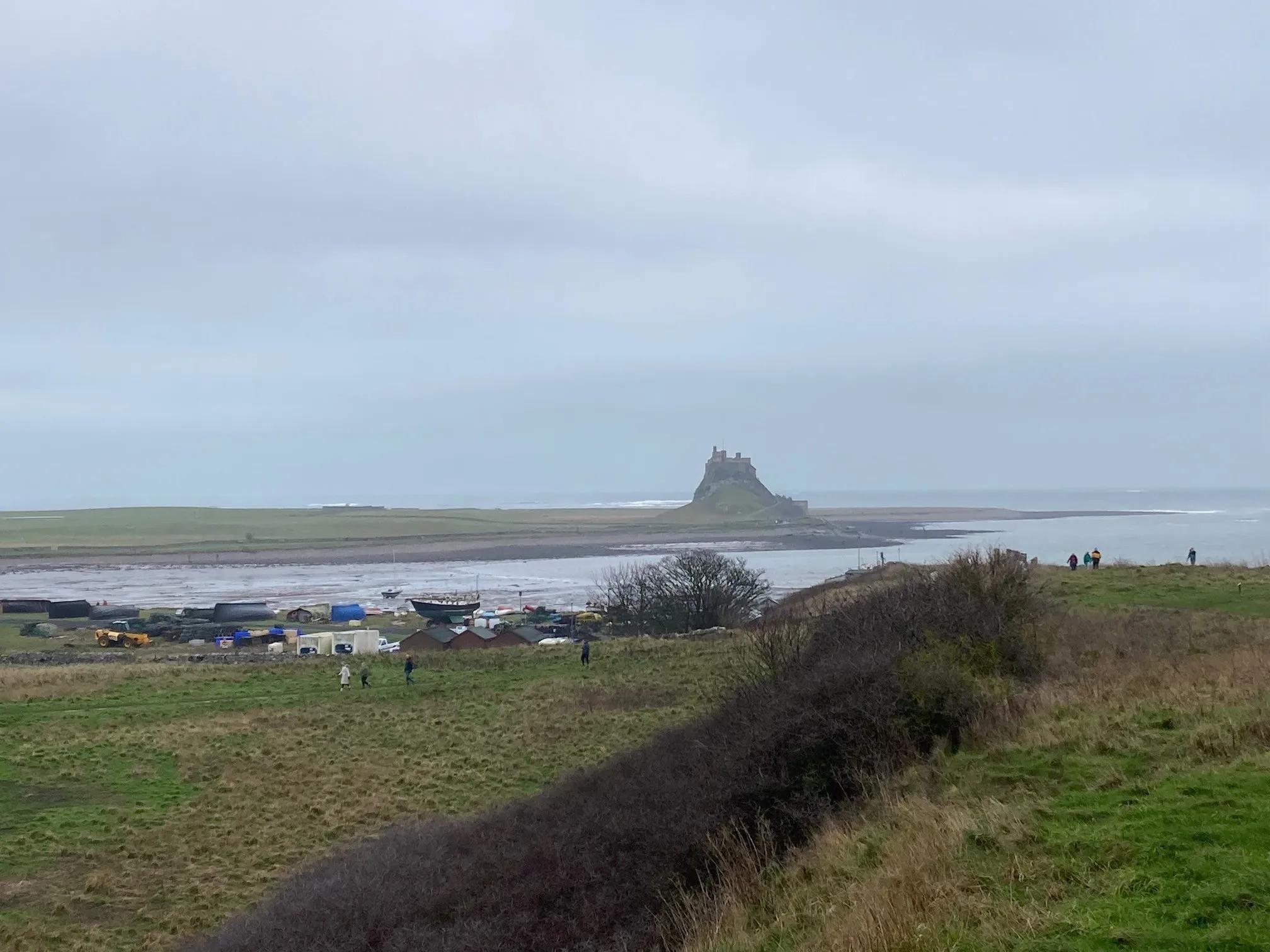 The view of a castle in the distance as seen from shore