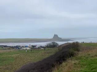 The view of a castle in the distance as seen from shore