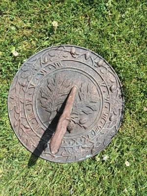 A sun dial on a grass floow