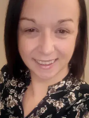 A photo of Karen in front of a white wall