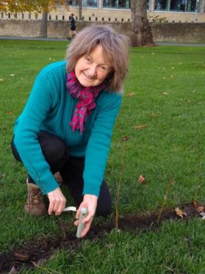 Tricia gardening while smiling at the camera