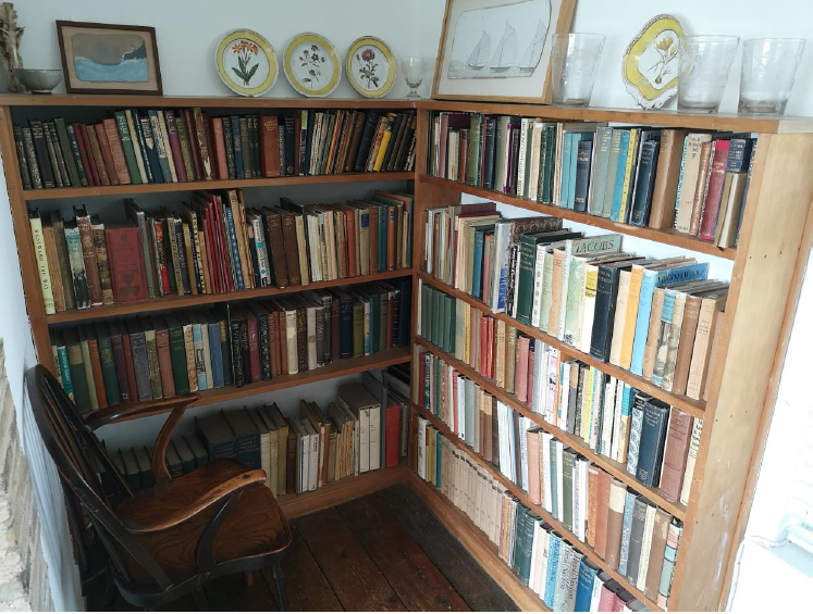 Photograph of a chair surrounded by bookshelves filled with books. 