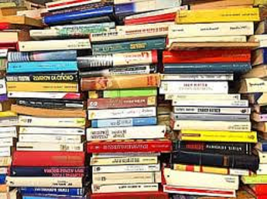 Photograph of 3 stacks of books stacked on top of each other. There are books with lots of different coloured covers. 