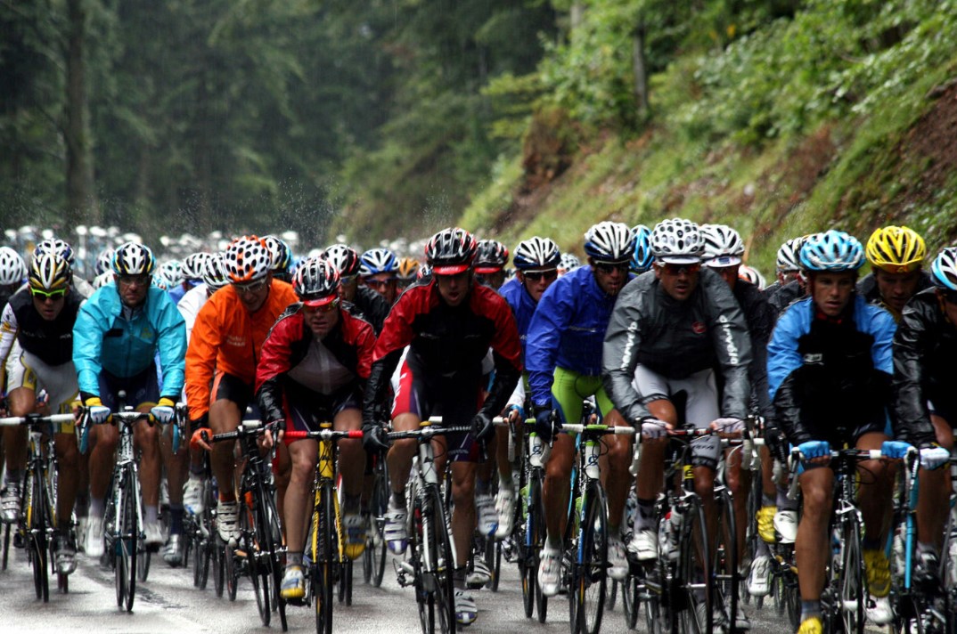 Photograph of a cyclist peloton in the rain